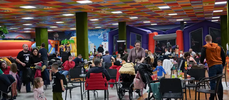 A zsúr- és vendéglátó tér asztalokkal, tele családokkal